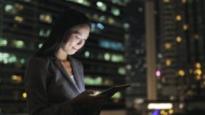 Businesswoman using digital tablet at night